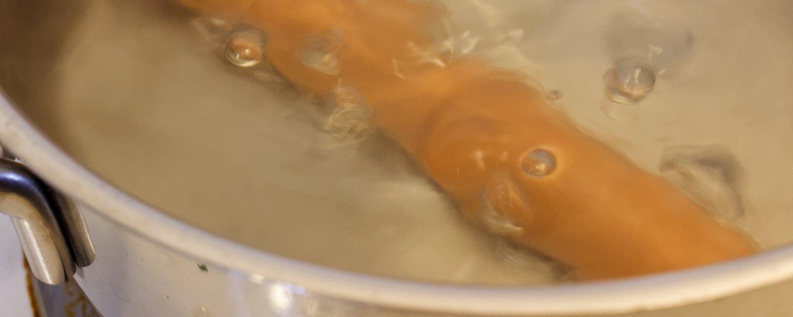 Sausage cooking in boiling water